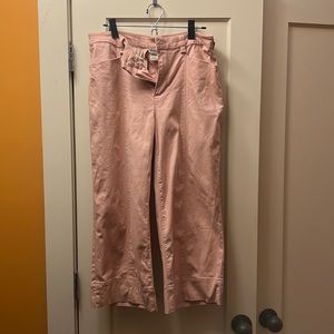 High-waisted pale, Blush pink cropped trousers.